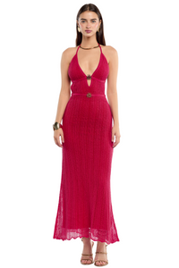 Mujer usando un maxi vestido tejido en rojo, adornado con dijes de estrella con espalda descubierta y tiras amarrables.