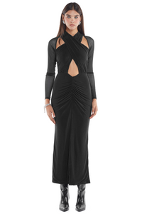 Mujer usando un vestido de tul negro, con forro interior, ligera abertura en la zona de la barriga y escote halter amarrable y ajustable al cuello.